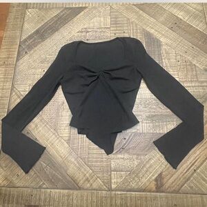 Asymmetrical black long sleeve top with a sexy scoop neckline & irregular hem